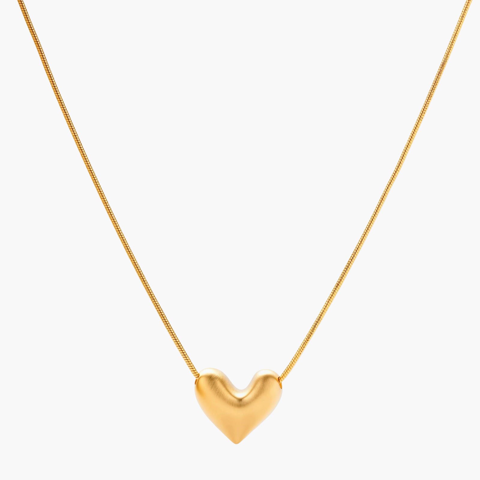 Dainty 18K gold-plated sterling silver necklace with small heart pendant on delicate chain against cream background.