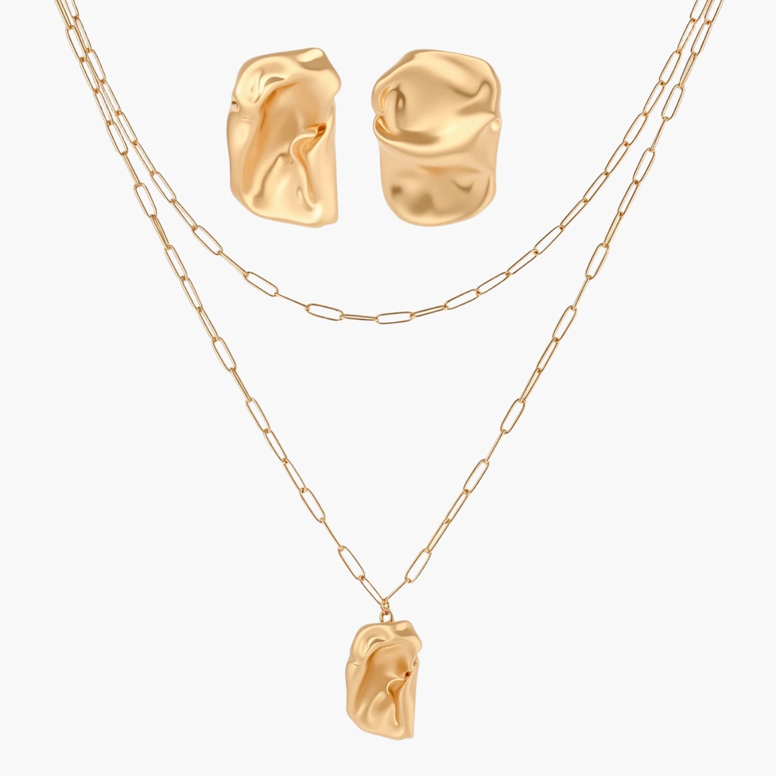 Sculptural gold-toned jewelry set with organic fluid shapes including earrings and layered chain necklace on cream background.