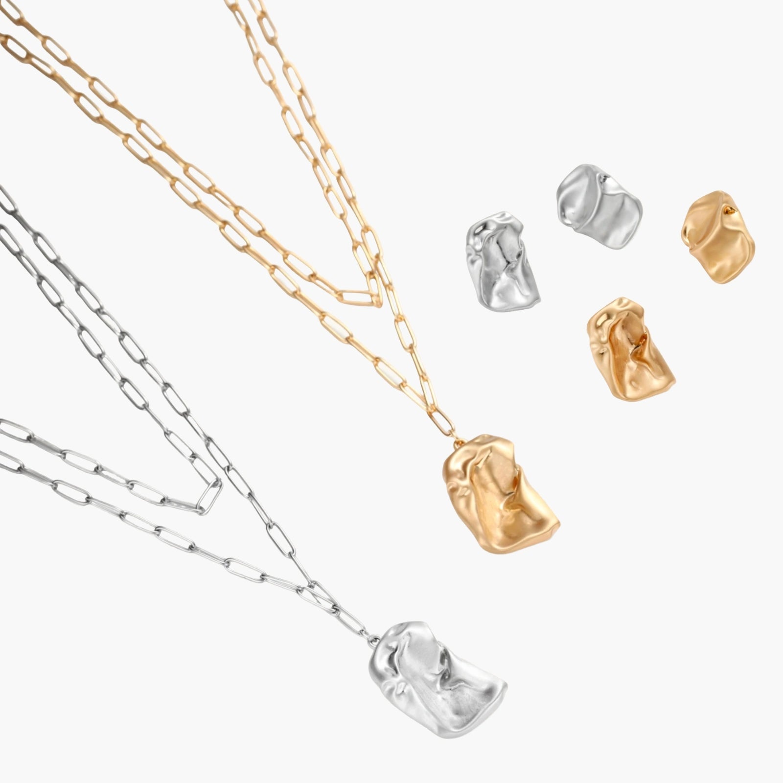 Sculptural gold-toned jewelry set with organic fluid shapes including earrings and layered chain necklace on cream background.